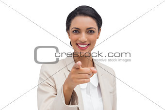 Smiling businesswoman pointing at camera
