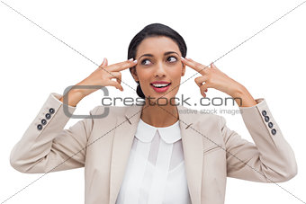 Confident young businesswoman pointing her head with her fingers