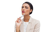 Thoughtful young businesswoman holding a pen