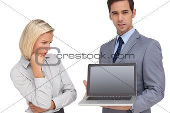 Businesswoman looking at colleagues laptop