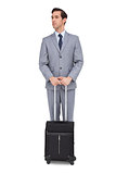 Serious businessman waiting with his luggage