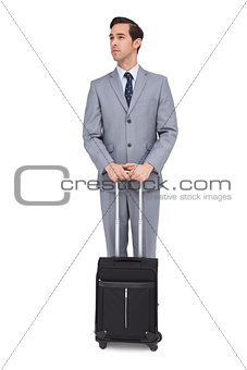 Serious businessman waiting with his luggage