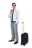 Happy businessman waiting next to his luggage