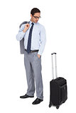 Serious businessman looking at his luggage