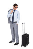 Smiling businessman looking at his suitcase