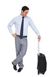 Businessman waiting while holding his luggage