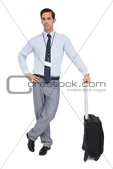 Serious businessman next to his suitcase