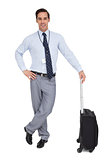Smiling businessman next to his suitcase