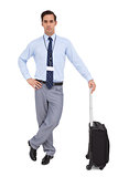 Handsome young businessman waiting with his suitcase
