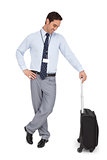 Businessman looking at his suitcase and smiling