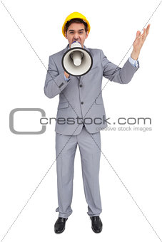 Architect with hard hat shouting with a megaphone