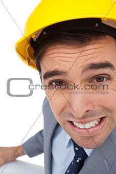 Close up of architect with hard hat grimacing while holding plans
