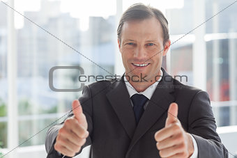 Smiling businessman giving thumbs up