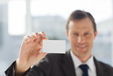 Smiling businessman showing business card