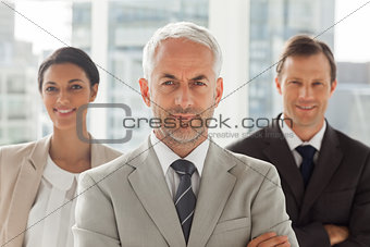 Businessman standing with colleagues behind