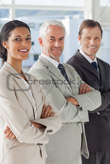 Three smiling business people standing together