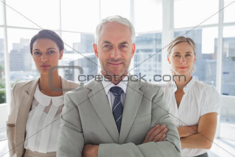 Confident businessman standing in front of colleagues