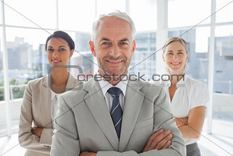 Smiling businessman standing in front of colleagues