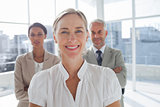 Smiling businesswoman standing in front of colleagues