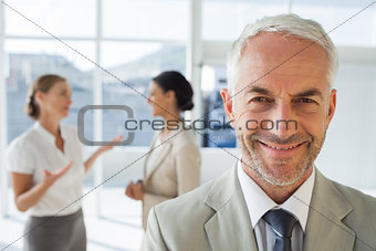 Smiling businessman standing in front of colleagues