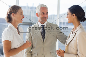 Likeable businessman speaking with female colleagues