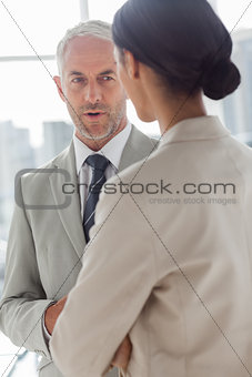 Concentrated businessman listening to female colleague