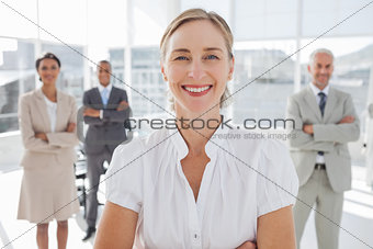 Cheerful businesswoman standing with arms folded