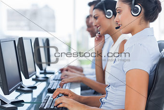 Call centre workers sitting in line while helping people
