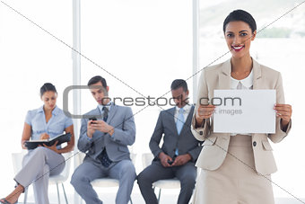 Smiling businesswoman holding a blank notice
