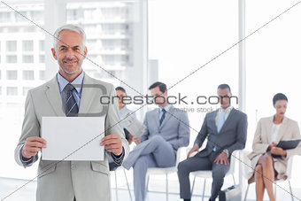Smiling businessman holding a blank notice