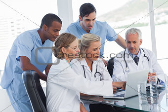 Serious medical team using a laptop