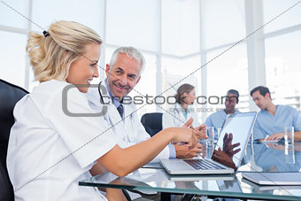 Two smiling doctors looking at a laptop