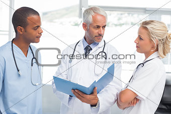 Three doctors examining a file