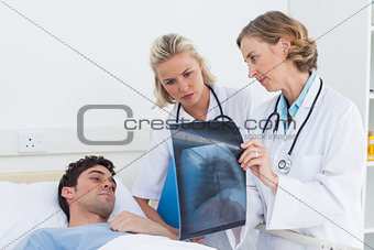 Doctors showing radiography to a patient