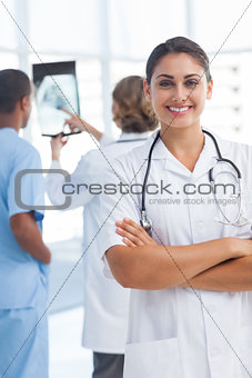 Young woman doctor with arms crossed looking at the camera