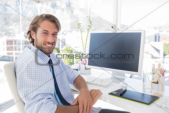 Smiling designer sitting at his desk