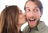 Woman kissing man with beard on the cheek