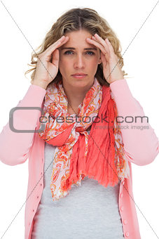Blonde woman touching her temples because of a headache
