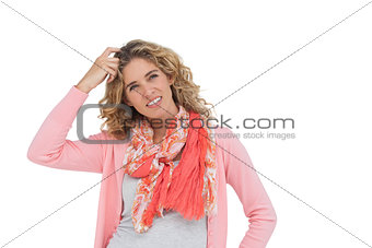 Woman posing and smiling while scratching her head