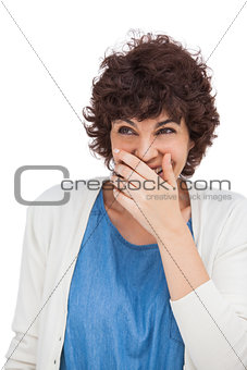 Smiling woman with hand on her mouth