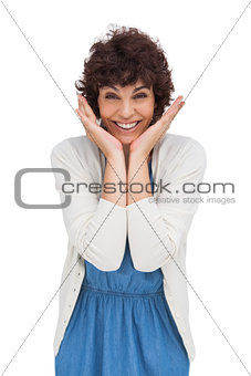 Astonished brunette woman standing and smiling