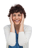 Cheerful brunette woman holding her head between hands