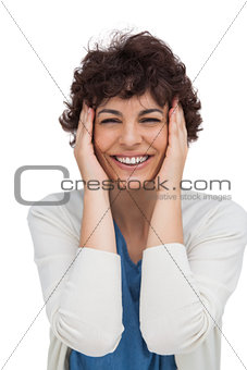 Cheerful brunette woman holding her head between hands