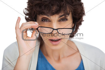 Portrait of a shocked woman looking over her glasses
