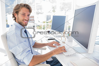 Smiling designer working at his desk