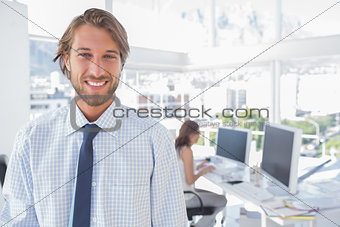 Smiling desginer standing in office