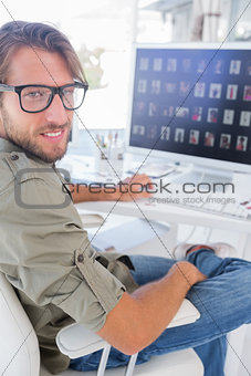 Smiling photo editor at his desk