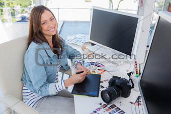 Cheerful photo editor working with a graphic tablet