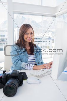 Cheerful photo editor working on computer