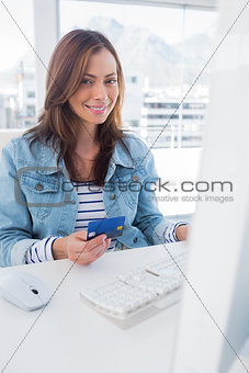 Smiling woman purchasing online with her credit card